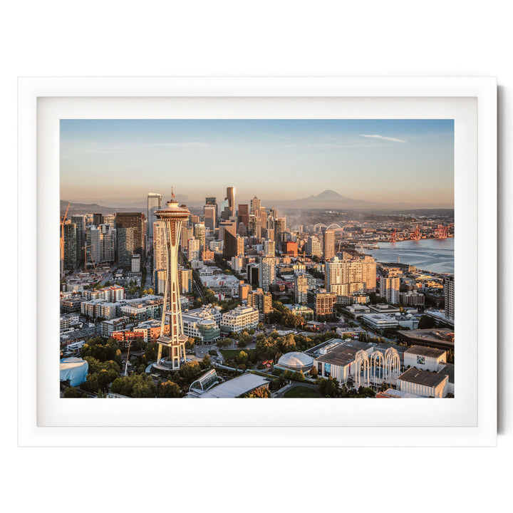 a cityscape with a tall tower, likely a landmark, surrounded by a variety of buildings and skyscrapers. The city appears to be at sunset, with the warm colors of the sky creating a picturesque backdrop. The image is framed and appears to be a collage of multiple images, showcasing the city's skyline and architectural diversity.
