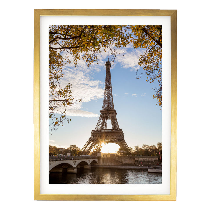the Eiffel Tower, a famous landmark in Paris, France, with a bridge and trees in the foreground.