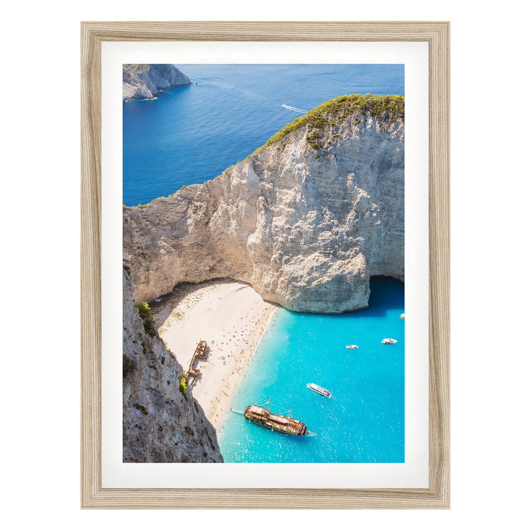 a picturesque coastal scene with a rocky cliff overlooking a turquoise sea dotted with boats.