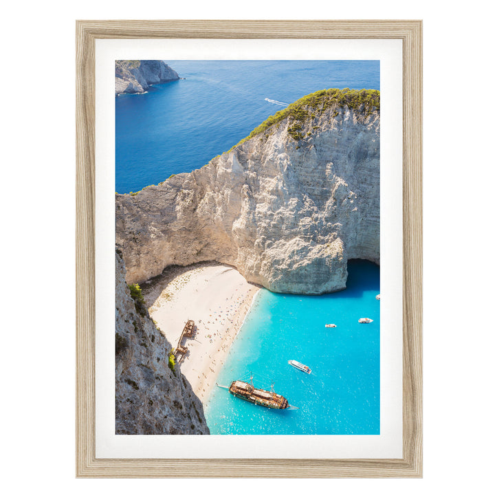 a picturesque coastal scene with a rocky cliff overlooking a turquoise sea dotted with boats.