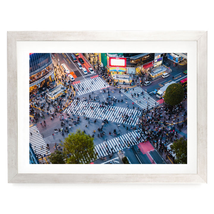 a busy city intersection with a large crowd of people crossing the street, surrounded by tall buildings and various advertisements.