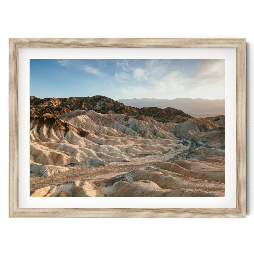 a rugged, mountainous landscape with a mix of rocky terrain and sandy areas, set against a clear blue sky.
