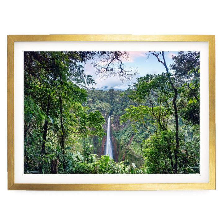 A lush, verdant forest with a majestic waterfall cascading down the rocky cliff face, framed in a gold frame.