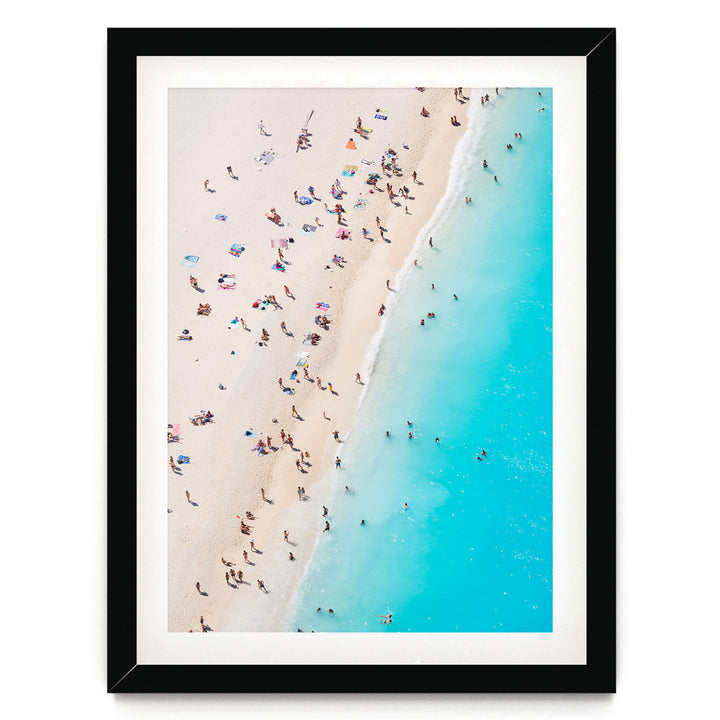 a crowded beach with people enjoying the sun and sand, with the ocean visible in the background.