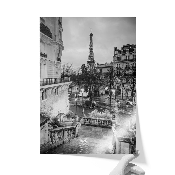 A black and white photograph of the Eiffel Tower in Paris, France, with the surrounding buildings and streets visible.
