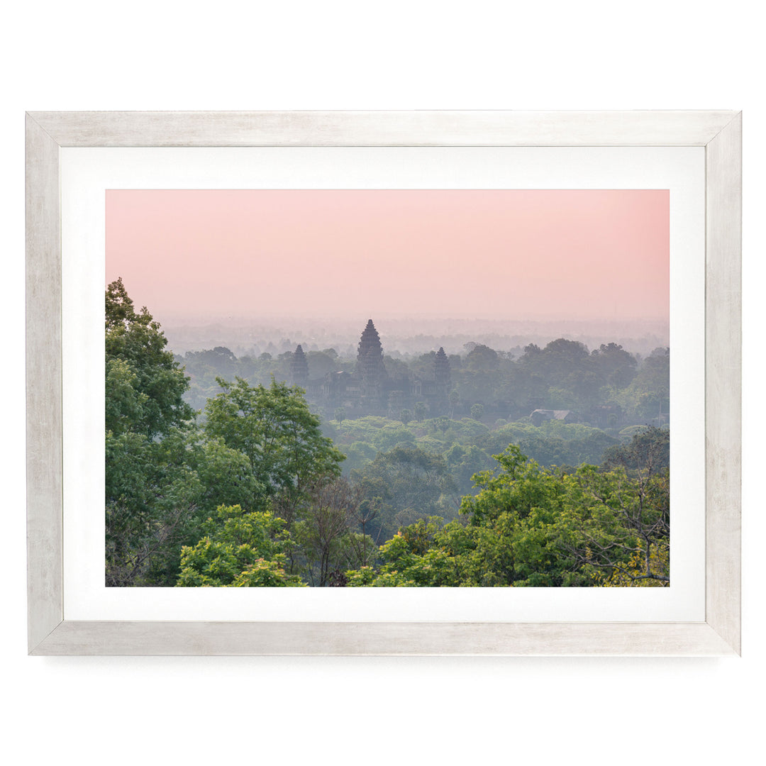 a serene landscape with a forested area and a temple in the distance, set against a hazy pink sky.
