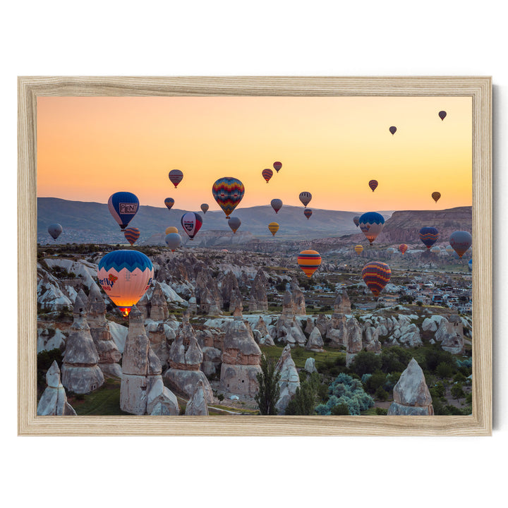 a breathtaking scene of hot air balloons floating over a mountainous landscape at sunset.