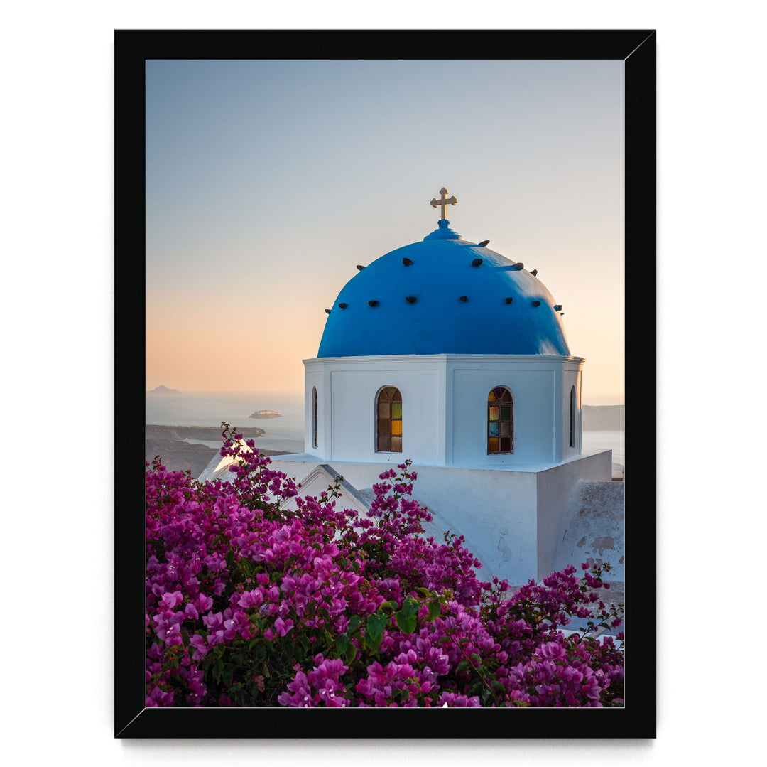 a blue domed church with a cross on top, surrounded by a vibrant display of purple flowers.