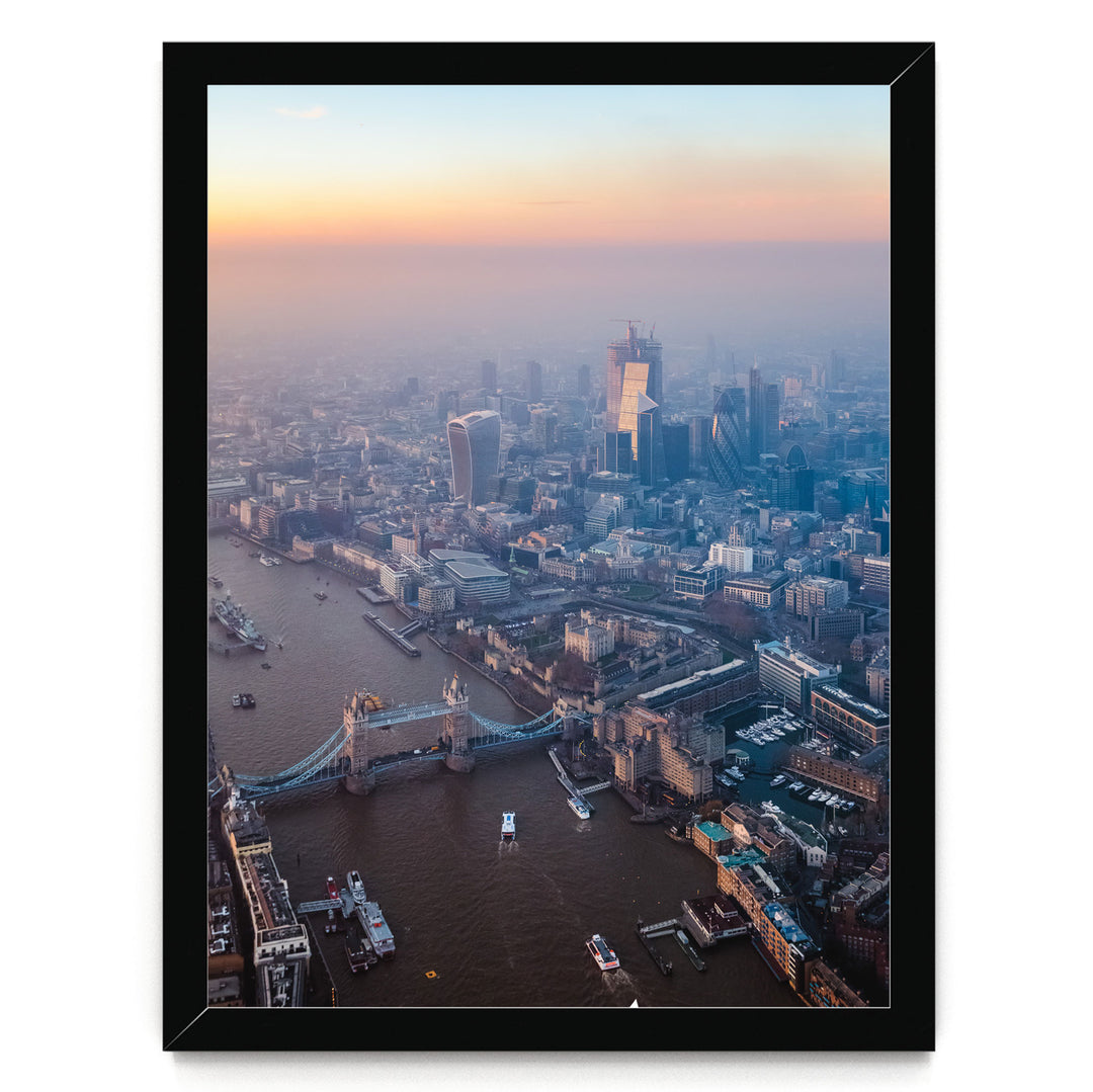 The image is an aerial view of a cityscape with a river running through it, featuring a bridge and boats on the water.