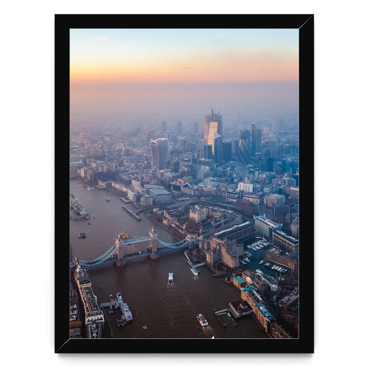 The image is an aerial view of a cityscape with a river running through it, featuring a bridge and boats on the water.