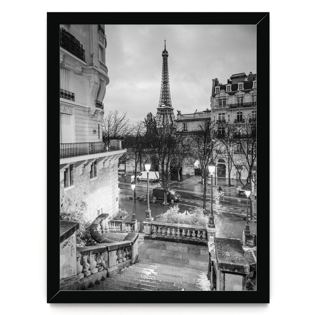 A black and white photograph of the Eiffel Tower in Paris, France, with the surrounding buildings and streets visible.