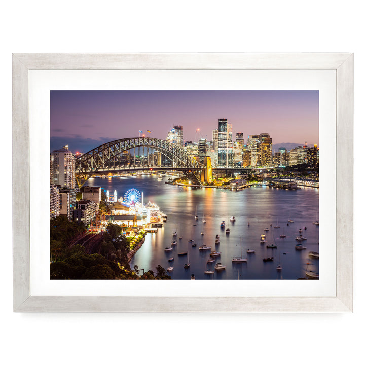 a city skyline at night, with a large bridge spanning a river filled with boats. The city is illuminated by the lights of the buildings, creating a vibrant and lively atmosphere.