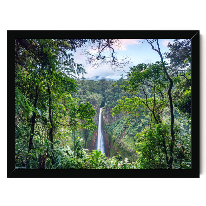 A lush, verdant forest with a towering waterfall cascading down the rocky cliff face, framed within a black border.