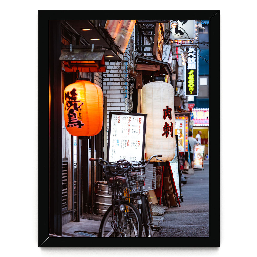 A bicycle parked on a street lined with colorful lanterns and signs, creating a vibrant and lively atmosphere.