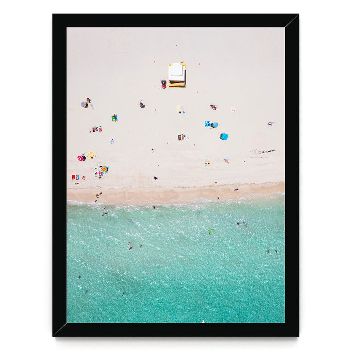 The image is an aerial view of a beach with people enjoying the water and sand.