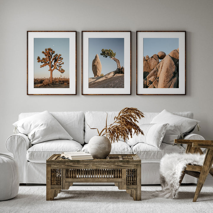 a living room with a white couch and three pictures on the wall