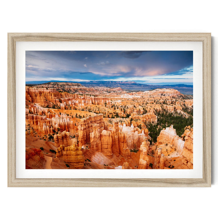 a breathtaking view of the rugged, orange rock formations of Bryce Canyon National Park, with a dramatic sky and clouds in the background.