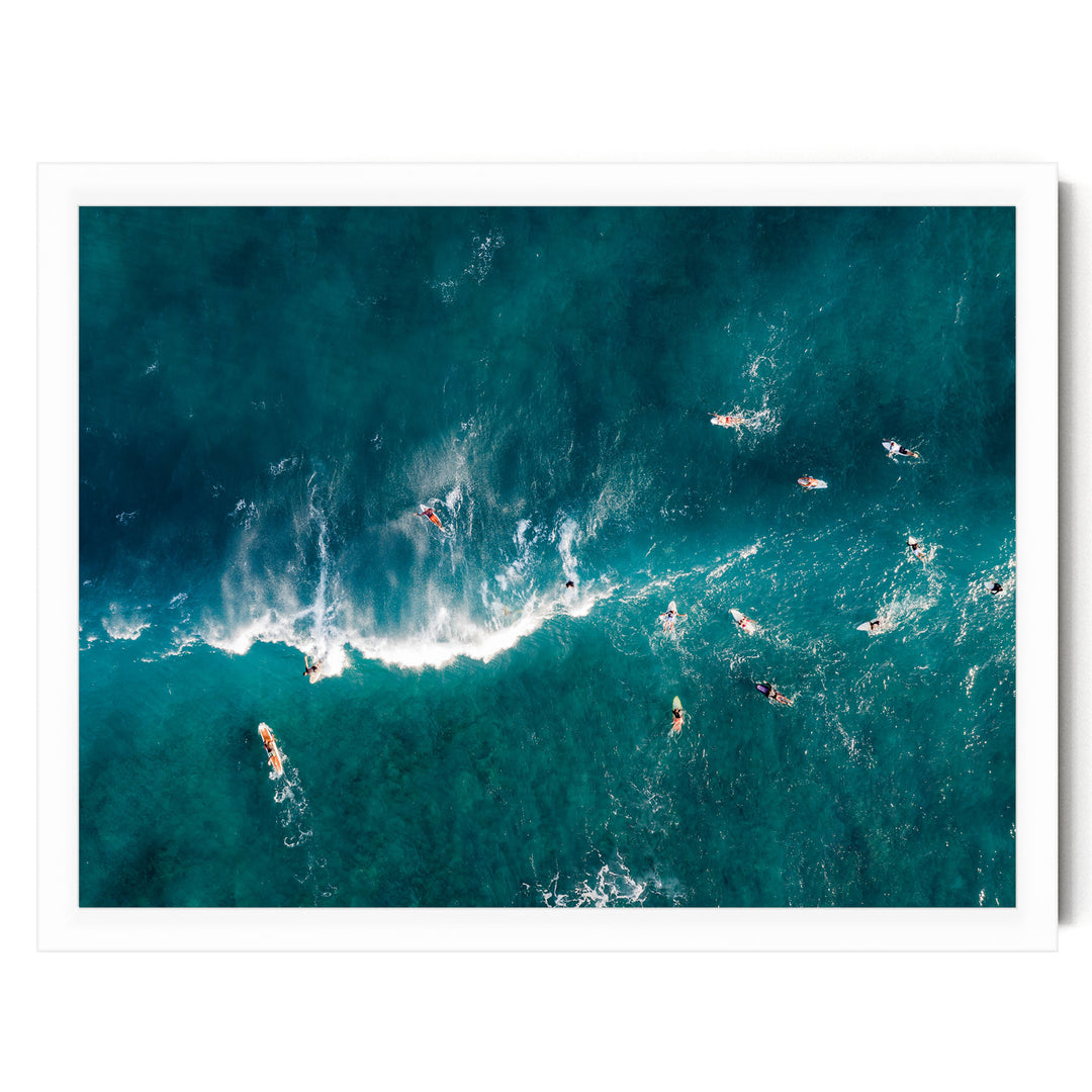 a group of surfers riding the waves in the ocean, with their surfboards visible beneath them.