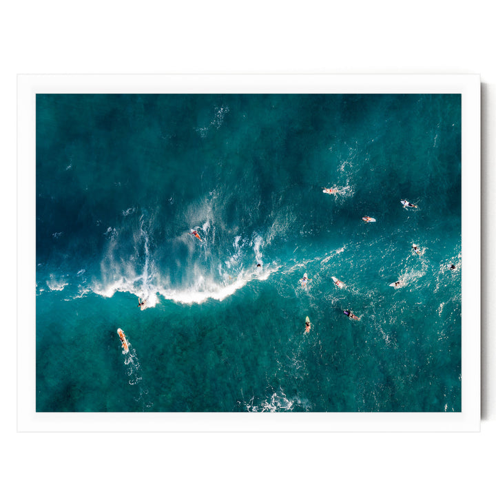 a group of surfers riding the waves in the ocean, with their surfboards visible beneath them.