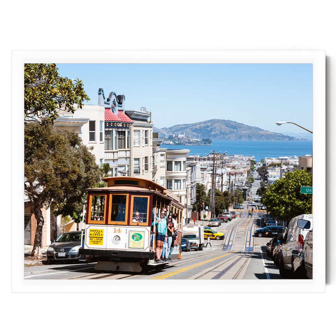 A cable car is traveling down a busy street in San Francisco, with buildings, cars, and pedestrians visible in the background.