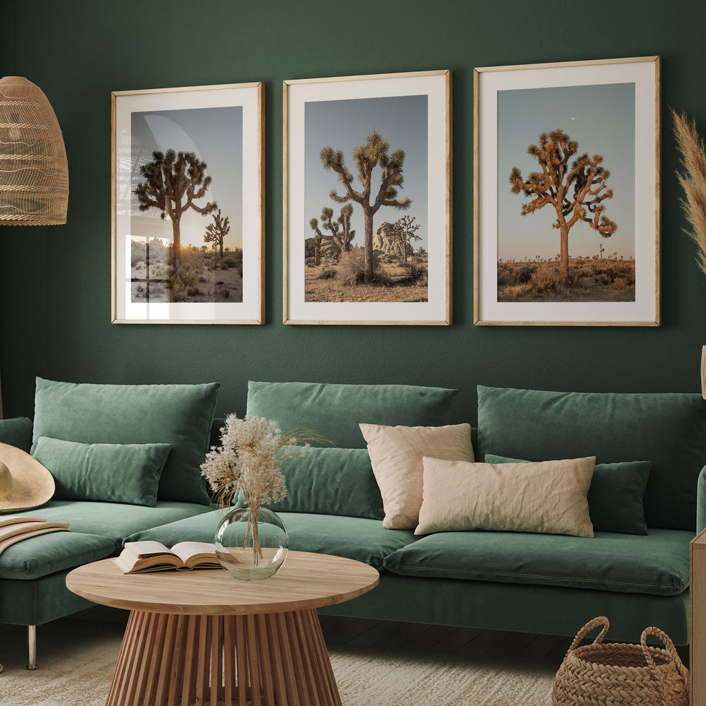 a living room with a green couch and two pictures on the wall