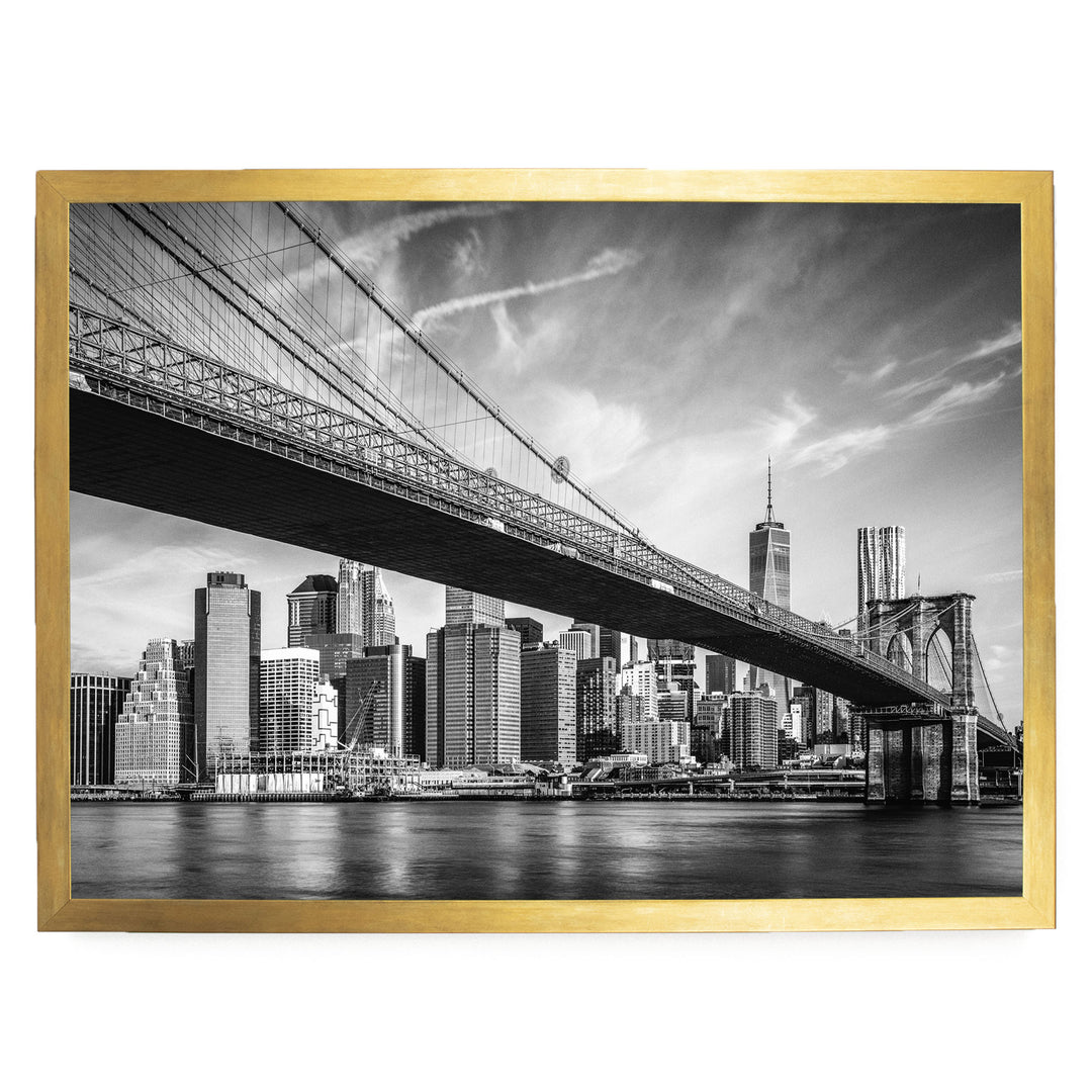 A black and white photograph of the Brooklyn Bridge in New York City, with the city skyline visible in the background.