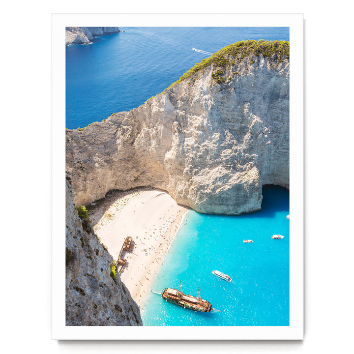 a picturesque coastal scene with a rocky cliff overlooking a beach and turquoise waters. Several boats are visible in the water, adding to the serene atmosphere.