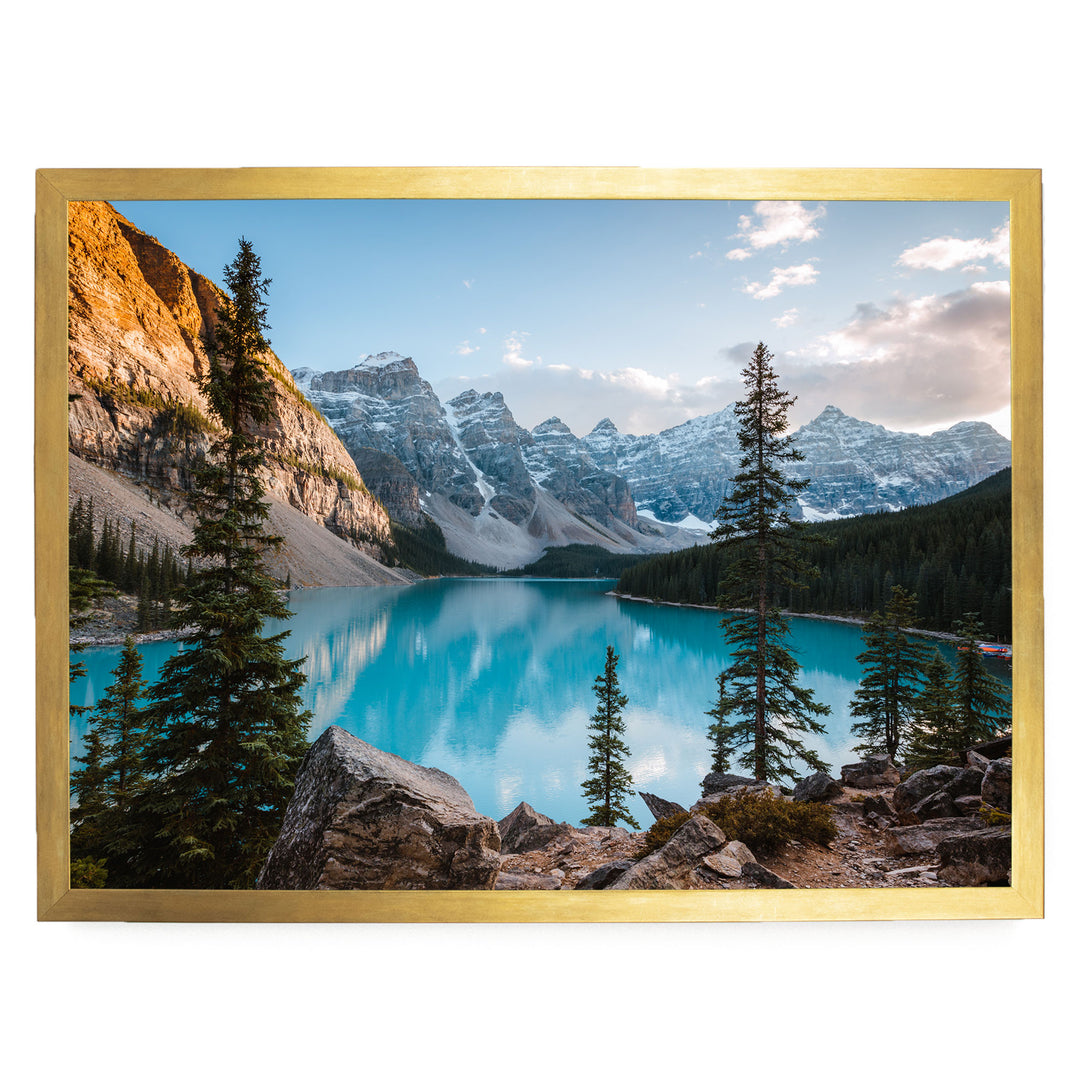 A breathtaking landscape featuring a serene turquoise lake surrounded by majestic snow-capped mountains, with pine trees lining the shore.