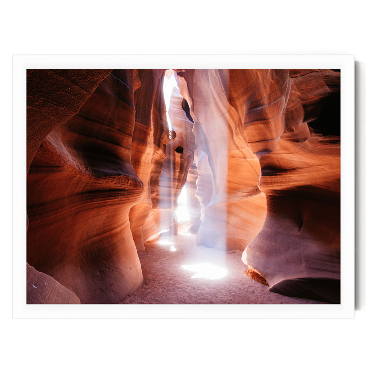 A stunning natural rock formation with a bright light shining through the narrow passage, creating a dramatic and captivating scene.
