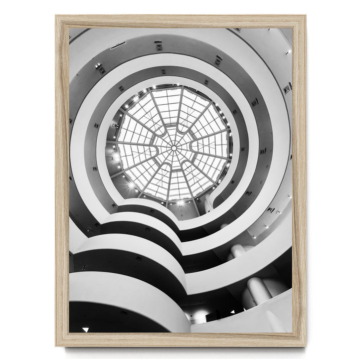 A black and white photograph of a modern, multi-level building with a large, circular glass dome at the top.