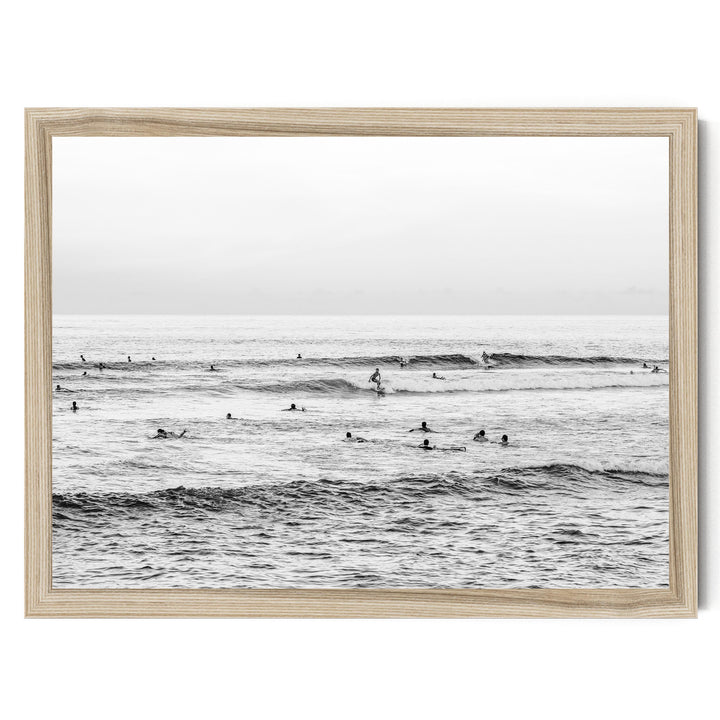 A group of people are enjoying the ocean waves, with some standing and others paddling on surfboards.