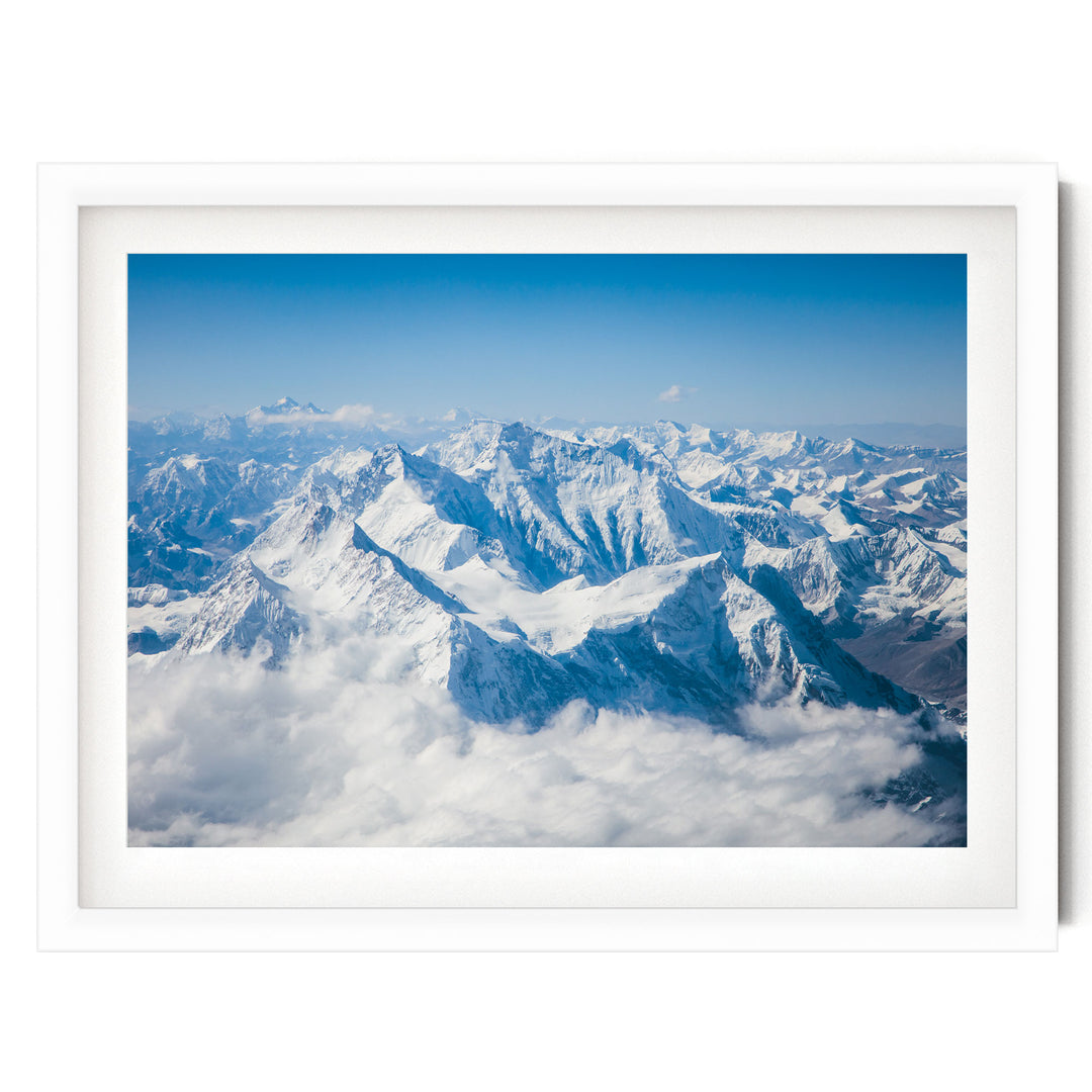 a breathtaking view of snow-capped mountains rising above a vast expanse of clouds, creating a stunning natural landscape.