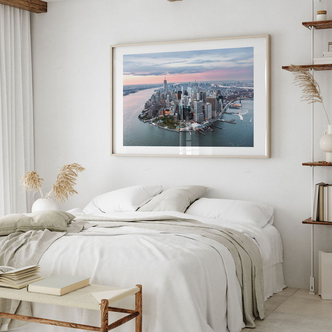 a bedroom with a large framed picture of a city skyline hanging on the wall above a bed with white bedding.