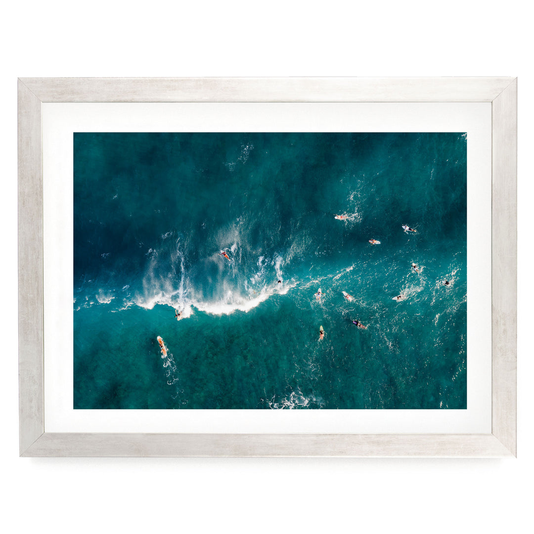 a group of people surfing on a large, turquoise ocean wave.