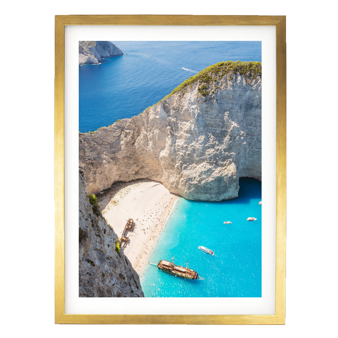 a picturesque coastal scene with a rocky cliff overlooking a turquoise sea dotted with boats.