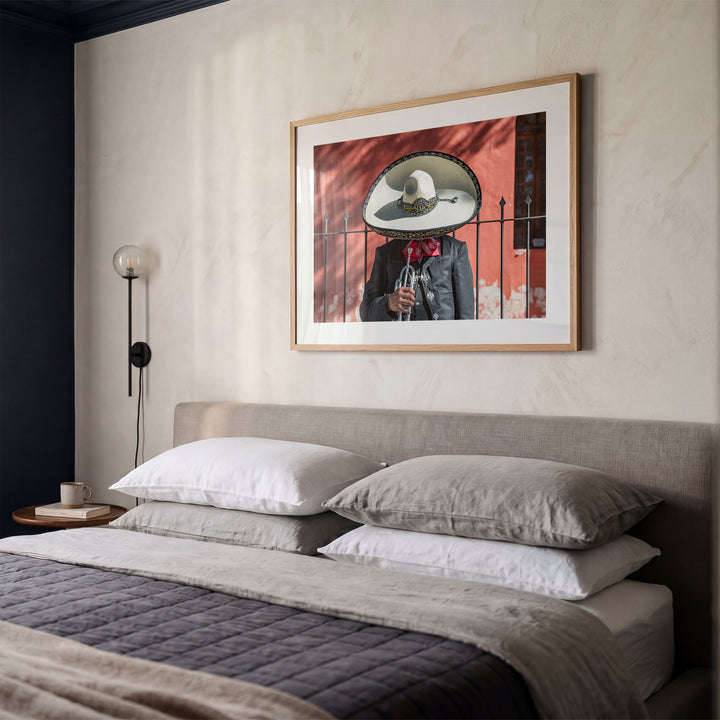 Framed Mexican charro print above a bed in a styled bedroom