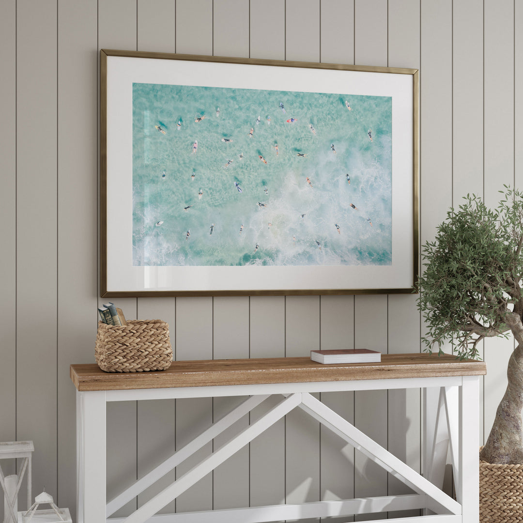 Framed Bondi Beach surfers print above a console table