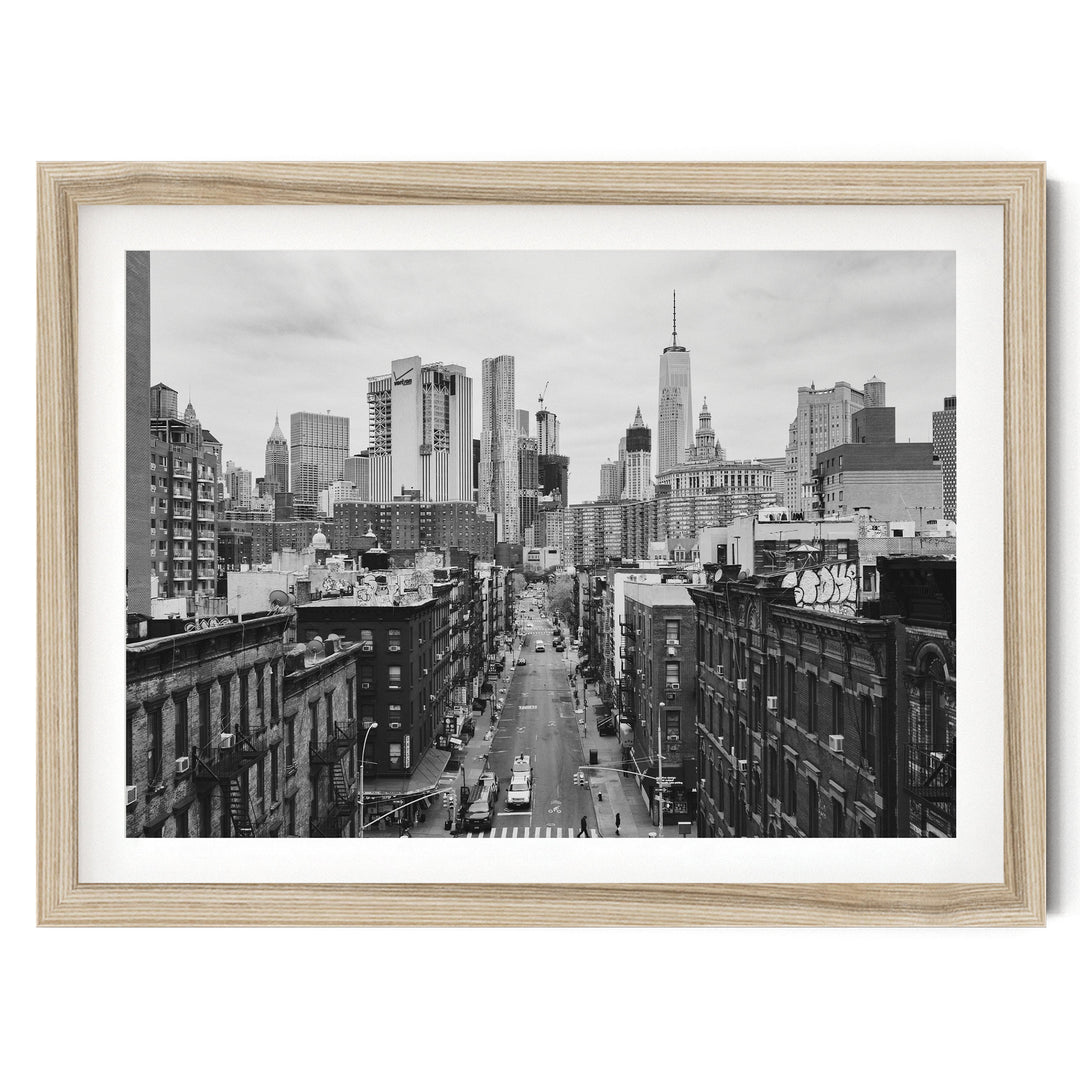 Lower Manhattan Street View, New York City – B&W fine art print in a natural wood frame with white mat