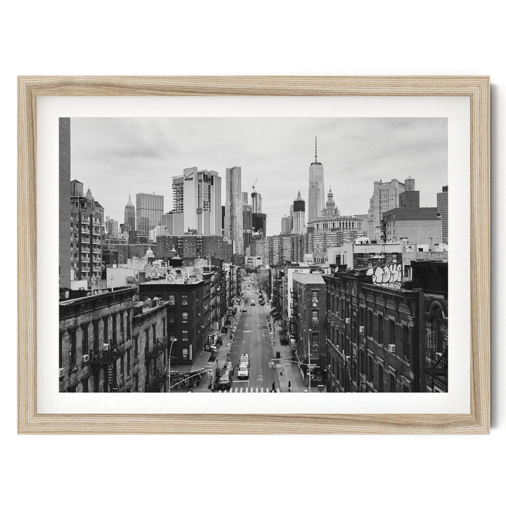 Lower Manhattan Street View, New York City – B&amp;W fine art print in a natural wood frame with white mat