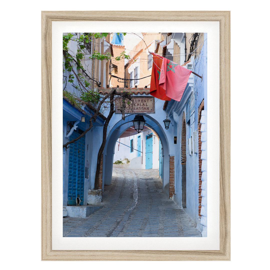 Moroccan Flag in the Blue City, Chefchaouen fine art print in a natural wood frame with white mat
