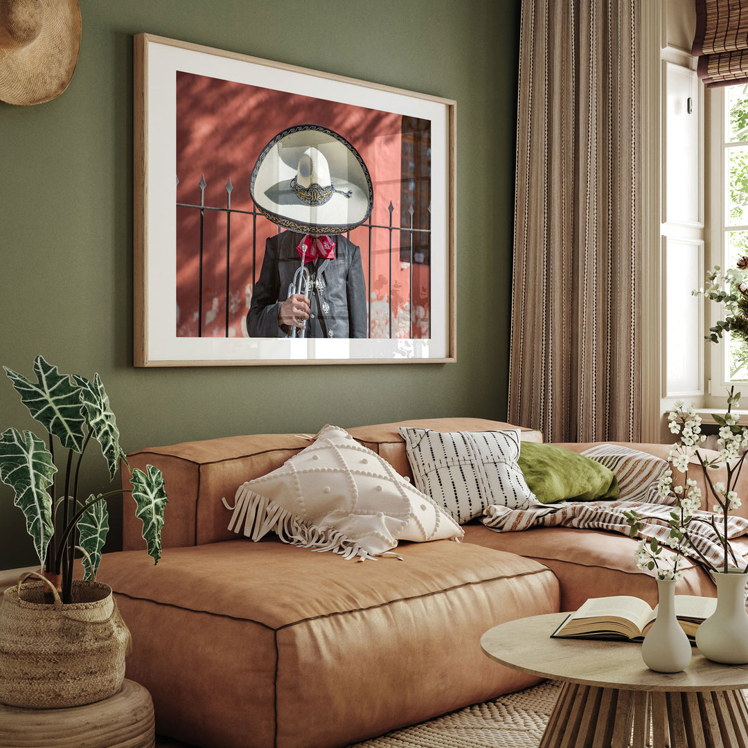 Framed Mexican charro print on a green wall above a sofa