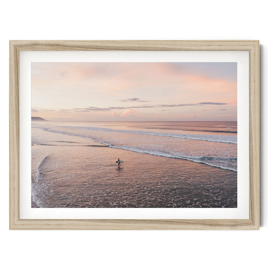 Lone Surfer on a Pink Beach II, Costa Rica fine art print in a natural wood frame with white mat