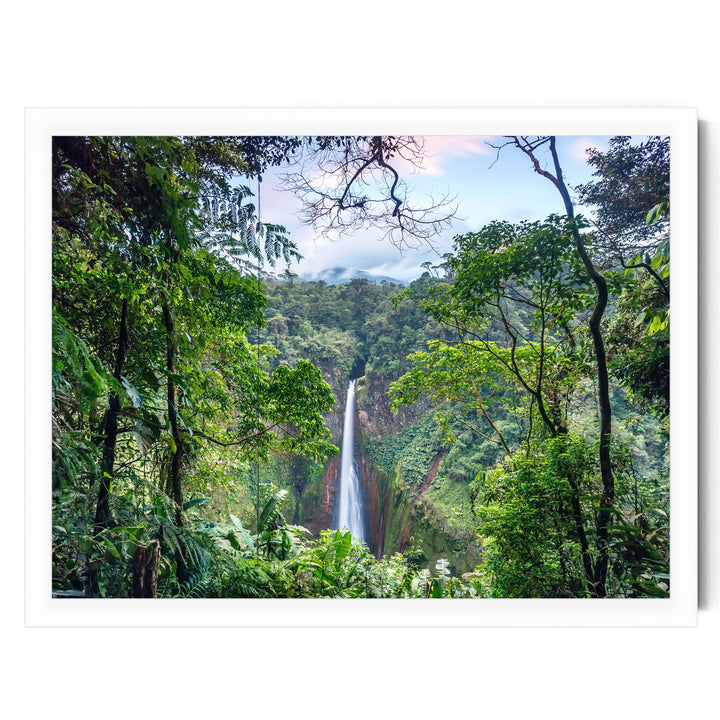 A lush, verdant forest with a towering waterfall cascading down the rocky cliffs in the distance.