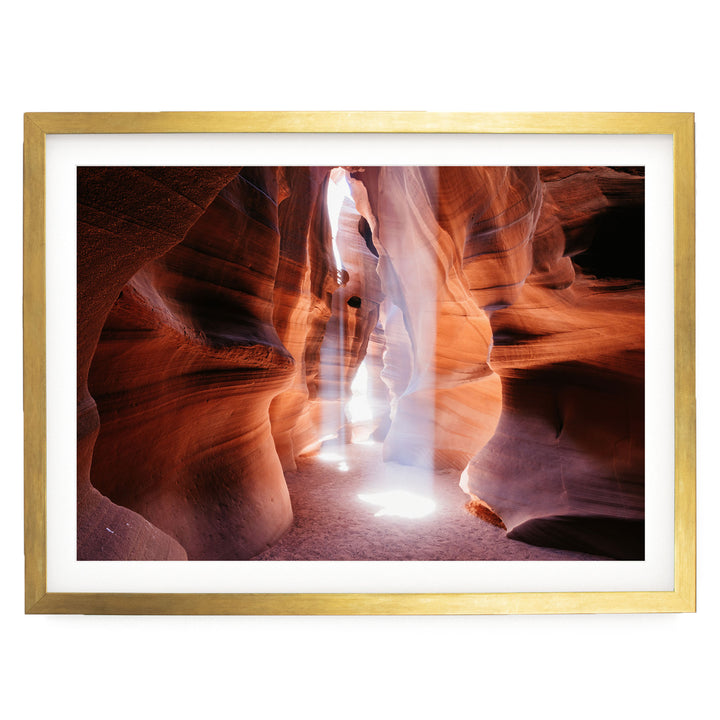 A framed photograph depicting a narrow passage in a canyon, with sunlight streaming through the walls and creating a dramatic, ethereal atmosphere.