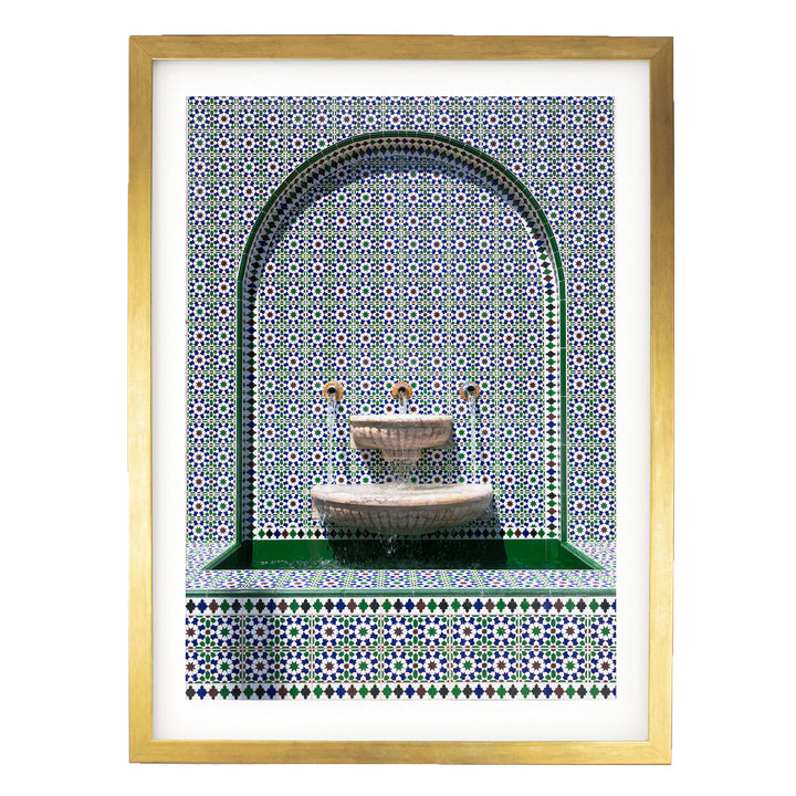 a decorative fountain with a green border and a tiled wall with a pattern of blue and white tiles.