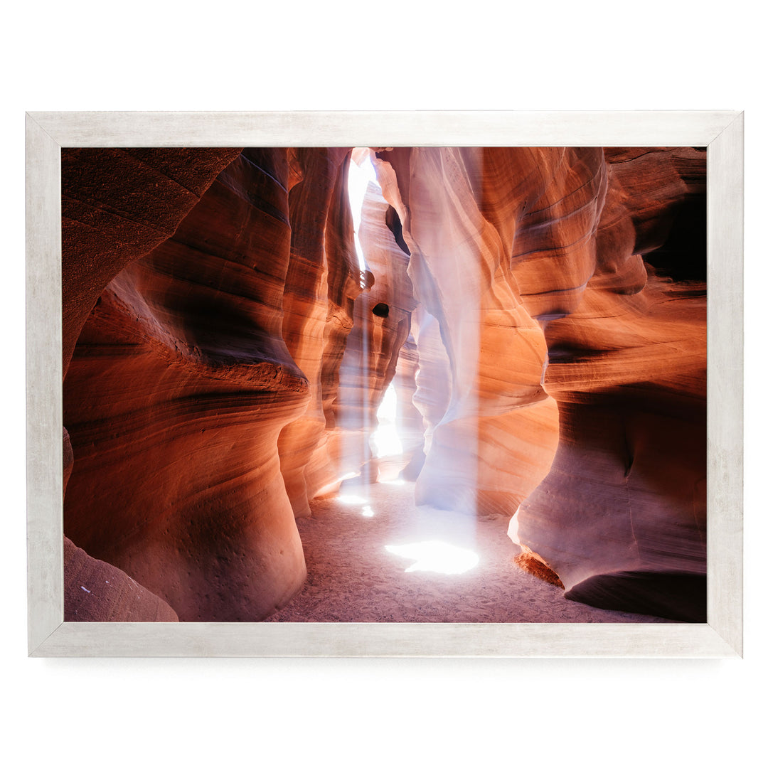 A framed photograph depicting a narrow, winding path through a canyon with vibrant red and orange rock formations, creating a dramatic and visually striking scene.