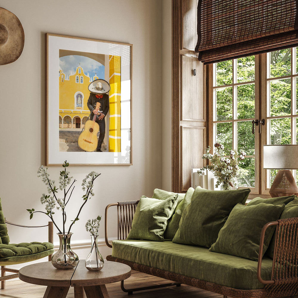a cozy living room with a large window overlooking a lush green outdoor scene. The room is furnished with a green sofa, a coffee table, and a framed painting of a person playing a guitar. The room is decorated with potted plants, vases, and other decorative items, creating a warm and inviting atmosphere.