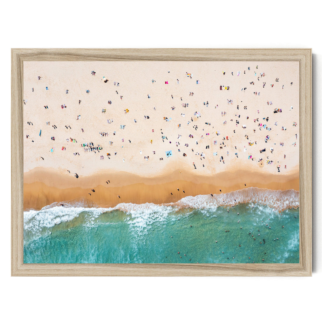 a crowded beach with people enjoying the sun and sand, with waves crashing onto the shore.