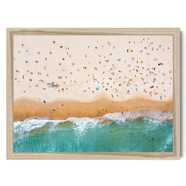 a crowded beach with people enjoying the sun and sand, with waves crashing onto the shore.