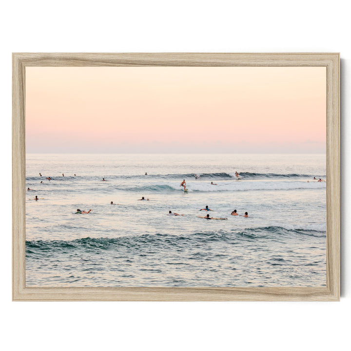 a group of people enjoying themselves in the ocean, with some swimming and others surfing on the waves.
